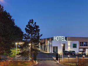 a hotel with cars parked in a parking lot at Berg'hotel in Socx