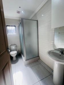a bathroom with a shower and a toilet and a sink at Luxury Executive Apartment in Vanderbijlpark