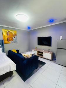 a living room with a couch and a flat screen tv at Luxury Executive Apartment in Vanderbijlpark