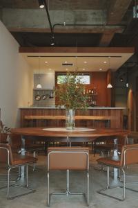 a dining room with a large wooden table and chairs at sunroom Hotel,Cafe,Bar in Miyazaki