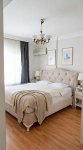 a bedroom with a large bed and a chandelier at Spacious Villa with Sea and Mountain View in Kemer +16 photos