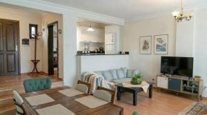 a living room with a couch and a tv at Spacious Villa with Sea and Mountain View in Kemer