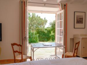 a room with a table and chairs and a sliding glass door at Hôtel La Figuière in Saint-Tropez