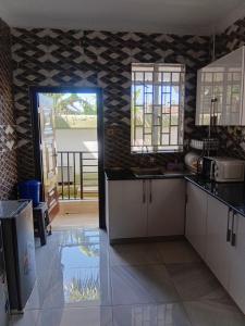 a kitchen with white cabinets and a door to a patio at SixPoint Victoria in Kisumu