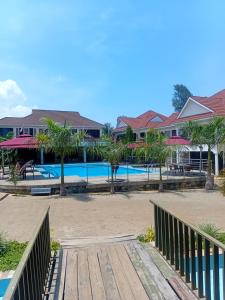 a boardwalk leading to a resort with a swimming pool at SixPoint Victoria in Kisumu