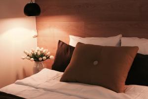 a bed with a pillow and a vase with flowers at Trudvang Apartment Hotel in Rena