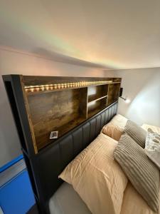 a bed with a wooden headboard in a room at Grant City Loft in Kaunas
