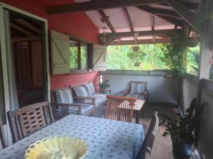 a screened in porch with a table and chairs at Kay Lydie in Saint-Joseph