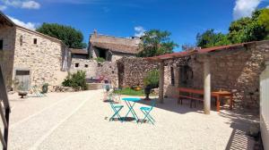 a patio with chairs and a table and a bench at La Grange de Sabatas in Chomérac
