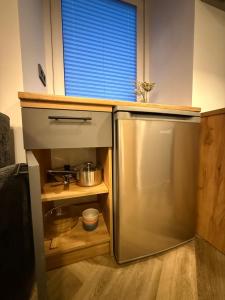 a small kitchen with a stainless steel refrigerator at Grant City Loft in Kaunas