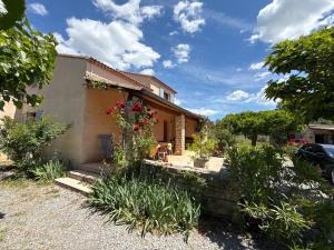 a house with flowers on the side of it at Chez Polo Villa avec piscine et pool house privé in Vallon-Pont-dʼArc