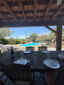 a black table with chairs and a bottle of wine at Chez Polo Villa avec piscine et pool house privé in Vallon-Pont-dʼArc +15 photos