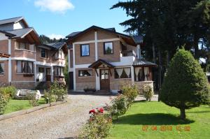 ein großes Haus mit einer Einfahrt davor in der Unterkunft Apart Bungalows Amulen in San Carlos de Bariloche