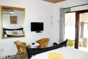 a bedroom with a bed and a mirror at B Cubed Lodge in Port Shepstone