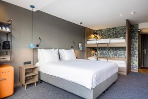 ein Schlafzimmer mit einem großen weißen Bett und einer Badewanne in der Unterkunft Van der Valk Hotel Eindhoven in Eindhoven + 53 Fotos