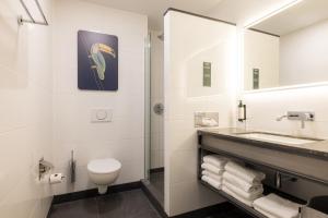 ein Badezimmer mit Toilette, Waschbecken und Spiegel in der Unterkunft Van der Valk Hotel Eindhoven in Eindhoven