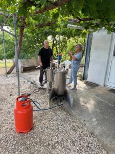 a couple of men standing next to a stove at Pervolaris Cottages 1 in Goudhi
