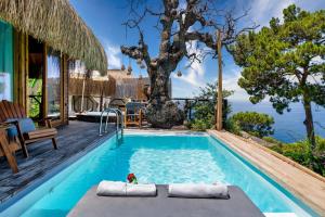 a swimming pool with a tree in the background at Heaven Resort Faralya in Fethiye