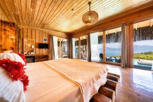 a bedroom with a large bed and large windows at Heaven Resort Faralya in Fethiye