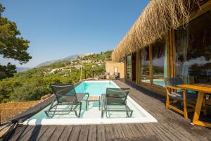 a deck with chairs and a swimming pool on a house at Heaven Resort Faralya in Fethiye