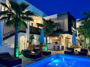 a resort with a pool and palm trees and a bar at Luminous luxury living in Kallithea Halkidikis