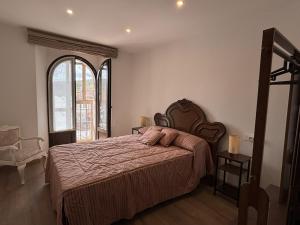 a bedroom with a large bed and a large window at Casa Dulcinea en Brañosera Montaña Palentina. in Brañosera