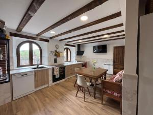 a kitchen with a table and a dining room at Casa Dulcinea en Brañosera Montaña Palentina. in Brañosera