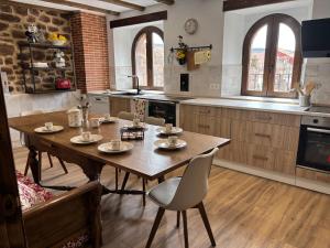 a kitchen with a wooden table and chairs at Casa Dulcinea en Brañosera Montaña Palentina. in Brañosera +36 photos