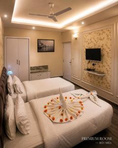 a bedroom with two beds and a flat screen tv at HOTEL RIO BENARAS in Varanasi
