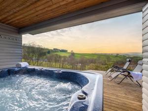 a hot tub on a deck with a view at 5 Bed in Llangammarch Wells oc-bn162 in Garth