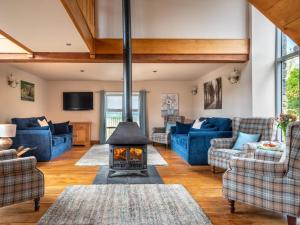 a living room with a fireplace and blue couches at 5 Bed in Llangammarch Wells oc-bn162 in Garth