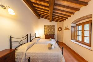 two beds in a bedroom with wooden ceilings at Countryhouse in Tuscany in Chianni +76 photos