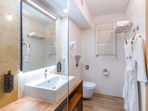 a white bathroom with a sink and a toilet at Mercure Opole in Opole