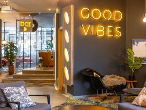 a lobby with a good vibes sign on a wall at Novotel Edinburgh Centre in Edinburgh