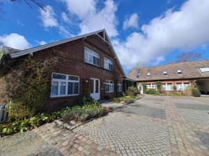a brick house with a driveway in front of it at Landhaus Gerdts - 2 in Cuxhaven