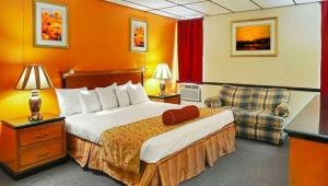a hotel room with a bed and a chair at M Star North Canton - Hall of Fame in North Canton +34 photos