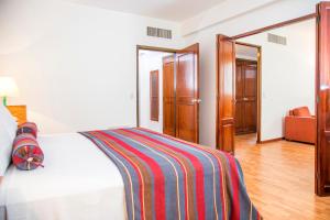 a bedroom with a bed with a striped blanket on it at San Agustin Riviera in Lima