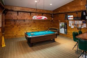 una mesa de billar en una habitación con paredes de madera en Deer Valley Trails, en Saint Regis Falls