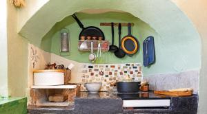 a kitchen with a counter with pots and pans on the wall at Danielle 626 House Ano Syros in Ano Syros
