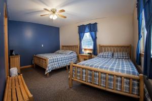 1 dormitorio con 2 camas y ventilador de techo en Deer Valley Trails, en Saint Regis Falls