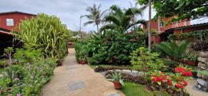 a garden with flowers and plants and a building at ROBINSON PLAGE Appartement in Lomé