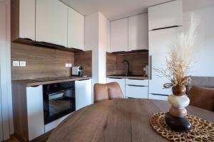 a kitchen and dining room with a wooden table at Apartma na Grad in Ptuj