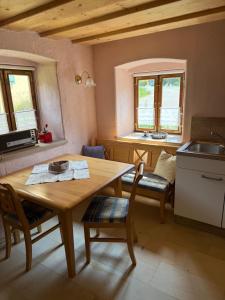 a kitchen with a wooden table and chairs and windows at Apostel Haus in Solnhofen
