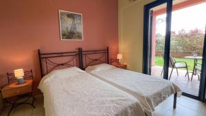 a bedroom with a bed and a sliding glass door at Ionian Bay Studios in Lefkada