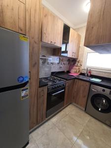 a kitchen with a refrigerator and a stove top oven at High quality apartment Madinty in Cairo