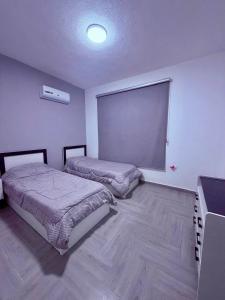 a bedroom with two beds and a large window at aqua chalets شاليهات أكوا in Al Rama