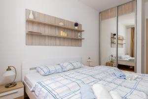 a white bedroom with a bed and a mirror at Lavender Bay Apartment C21 in Donji Morinj