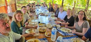 a group of people sitting at a long table eating food at Sasvi Cabana in Trincomalee
