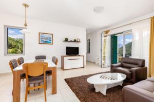 a living room with a couch and a table and chairs at Lavender Bay Apartment C21 in Donji Morinj