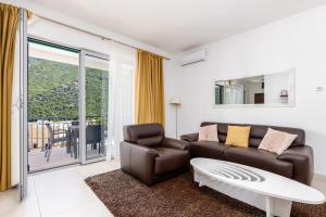 a living room with a couch and a coffee table at Lavender Bay Apartment C21 in Donji Morinj